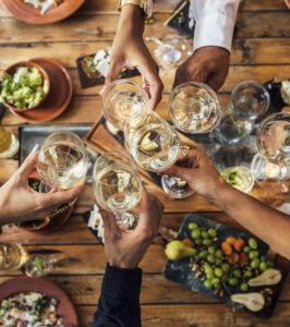 Des convives trinquent avec des verres de vins blancs Côtes de Gascogne autour d’une table conviviale